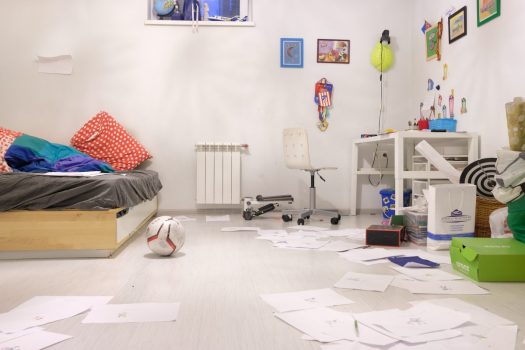 a messy white children's room with papers and toys everywhere