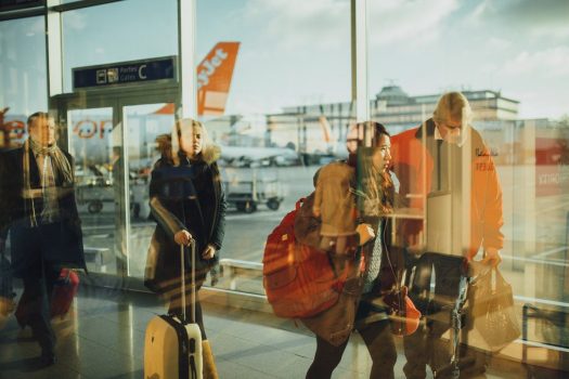 a busy airport scene with people and their suitcases