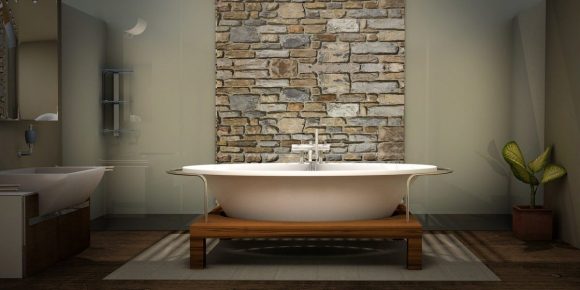 a bathtub in the center of a bathroom in front of a faux stone column