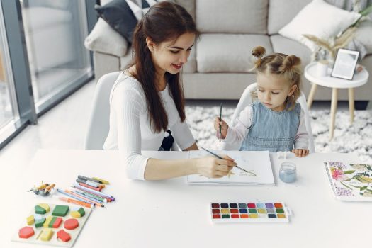 a woman and child paint together doing a spring art project