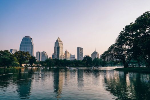 a city scape at dusk by a large lake