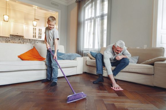 An older man and a young boy clean a floor together